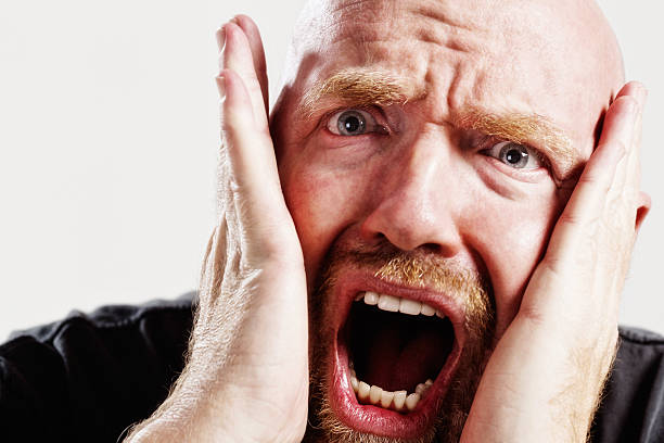 istock Balding mature man gasps, clutching his face in horror 174820747