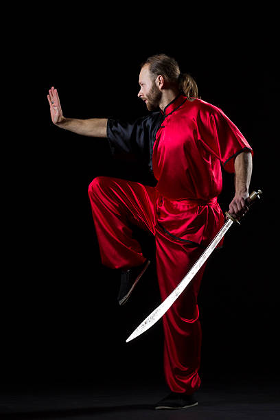 shaolin kung fu luta posição com dao espada sobre preto - self defense wushu action aggression imagens e fotografias de stock