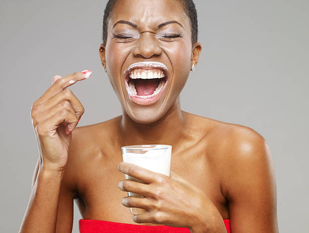 marca de leche alrededor de los labios de hermosa mujer afroamericana - mujer bebiendo leche fotografías e imágenes de stock