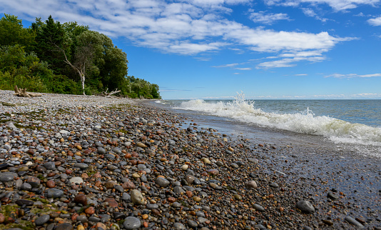 The chalk cliffs near Klein Zicker on the baltic sea island Ruegen and a sailing boat on a bright summer day