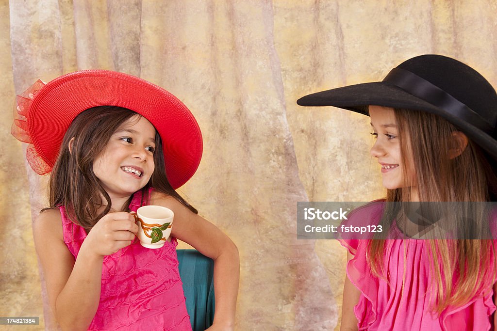 Due ragazze poco caucasico giocando 7-8, cappellini da party tazza di tè - Foto stock royalty-free di 6-7 anni