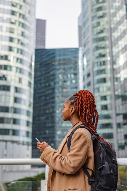 istock Young Woman Walking Through Paris Financial District While Holding Her Phone 1748214586