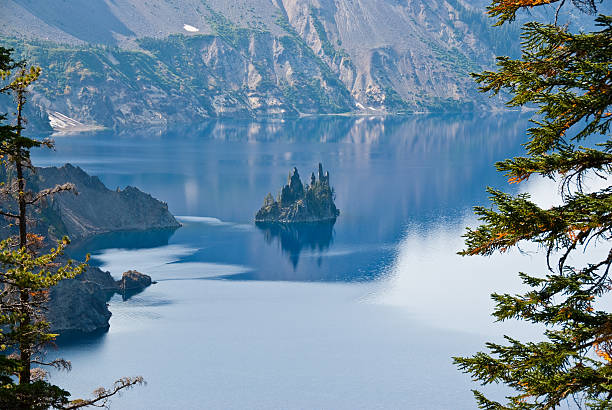 Phantom Ship Rock in the Fog Crater Lake exists in the blown-out caldera of a once mighty volcano known as Mount Mazama. This view of the lake and Phantom Ship Rock was taken from the Phantom Ship Overlook in Crater Lake National Park, Oregon, USA. jeff goulden crater lake national park stock pictures, royalty-free photos & images