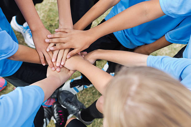 istock Kids soccer team huddled together during game; hands in circle 174822827