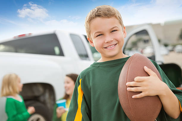 Young boy tailgating with family at football stadium Young boy tailgating with family at football stadium people family tailgate party outdoors stock pictures, royalty-free photos & images