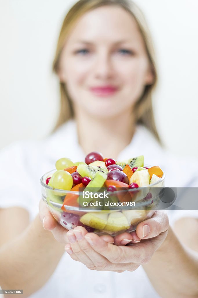 Young woman holding fresh raw fruit cut salad, posing indoors "Young woman holding fresh raw fruit cut salad, posing indoors." 30-39 Years Stock Photo