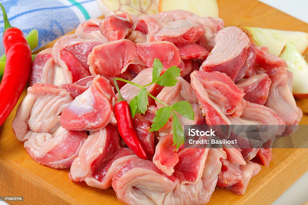 raw chicken gizzards heap of raw chicken gizzards on a wooden cutting board Meat Stock Photo