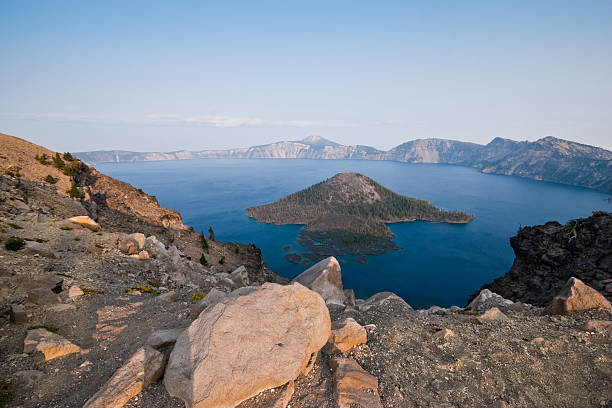 Crater Lake in the Evening Crater Lake exists in the blown-out caldera of a once mighty volcano known as Mount Mazama. This view of the lake and Wizard Island in the evening was photographed from Watchman Overlook in Crater Lake National Park, Oregon, USA. jeff goulden crater lake national park stock pictures, royalty-free photos & images