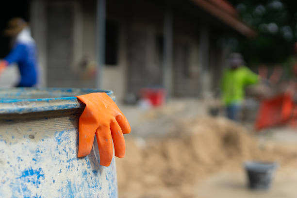 Orange glove hanging on the water tank at construction site, copy space background