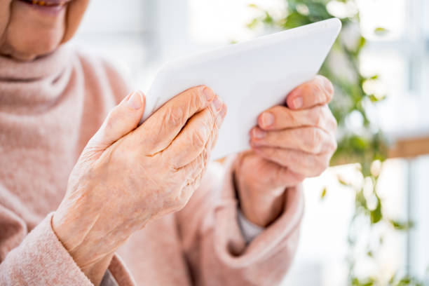 istock Elderly woman holding tablet 1748233115