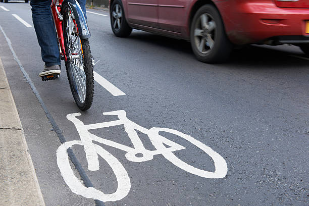 istock Man On Bike Using Cycle Lane As Traffic Speeds Past 174823352