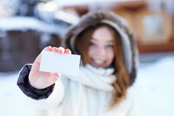 istock Winter. Girl with blank visiting card. 174823909