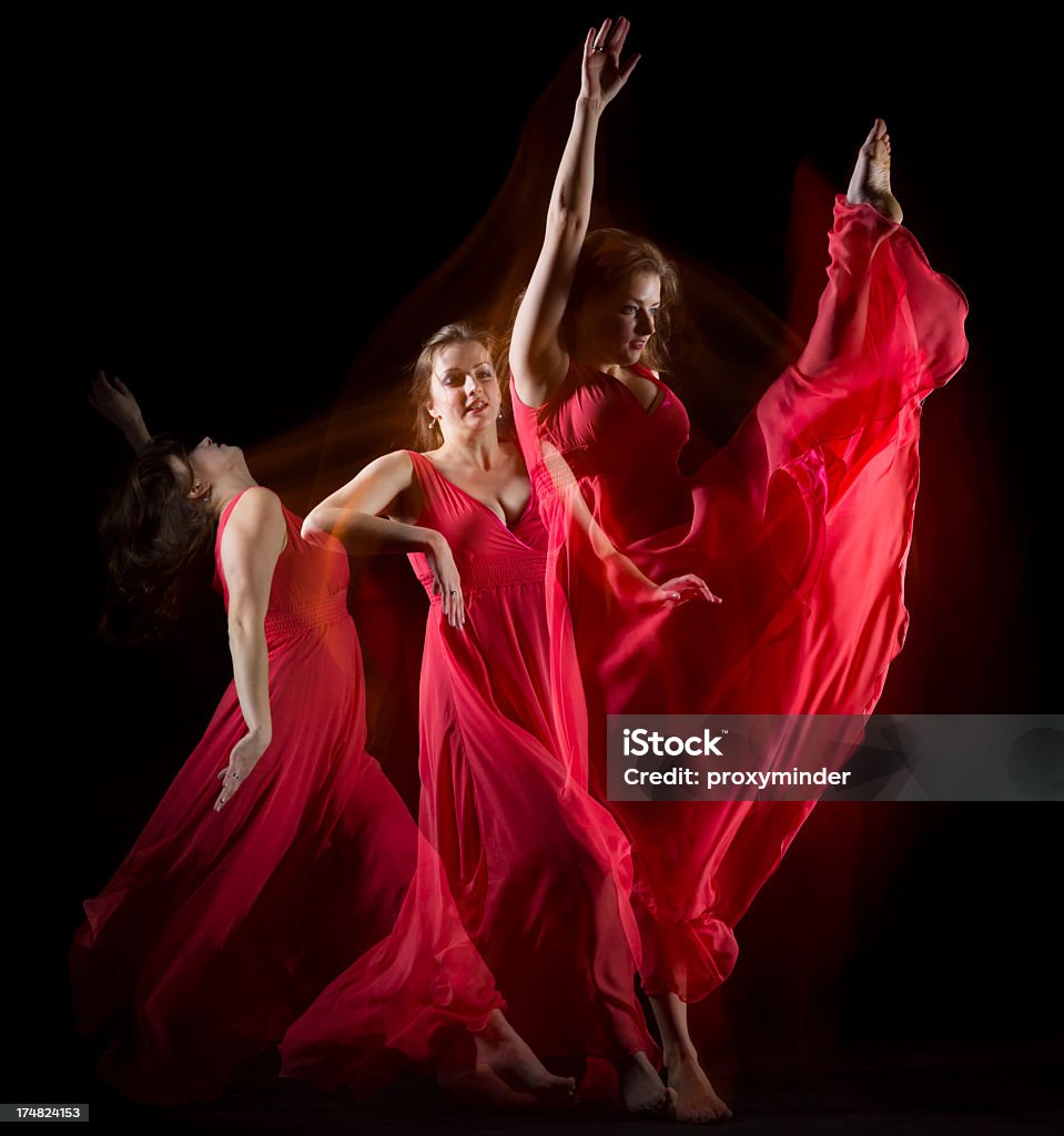 Kobieta tańczy w czerwony Strój tworzyć wzory na czarny - Zbiór zdjęć royalty-free (Akrobata)