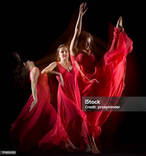 Kobieta Tańczy W Czerwony Strój Tworzyć Wzory Na Czarny - zdjęcia stockowe i więcej obrazów Akrobata