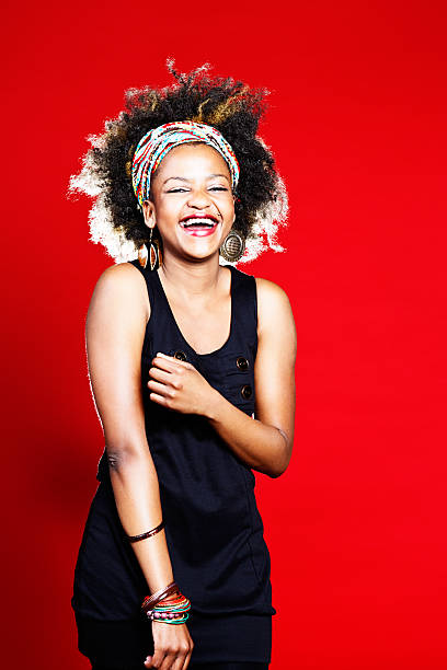 istock Laughing young cutie with wild afro-styled hair on red background 174824276