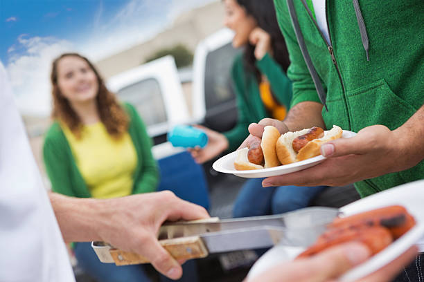 grupo de fãs com ir colado ao carro da frente de cozinhado no estádio de futebol americano - tailgate imagens e fotografias de stock