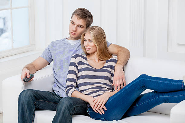 istock young caucasian couple sitting on couch holding remote control 174824411