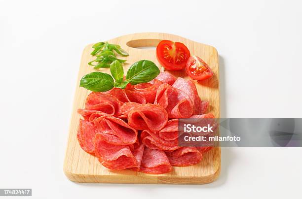 Rodajas De Salami Italiano En Una Tabla De Cortar Foto de stock y más banco de imágenes de Albahaca - Albahaca, Alimento, Alimento conservado