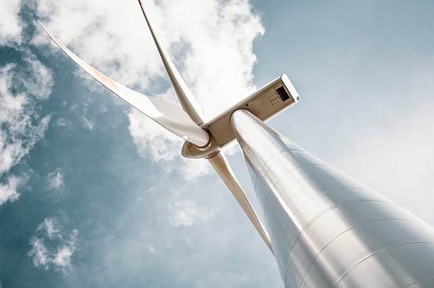 Wind turbine with blue gray sky Wind turbine in retro colors with added grain directly below stock pictures, royalty-free photos & images