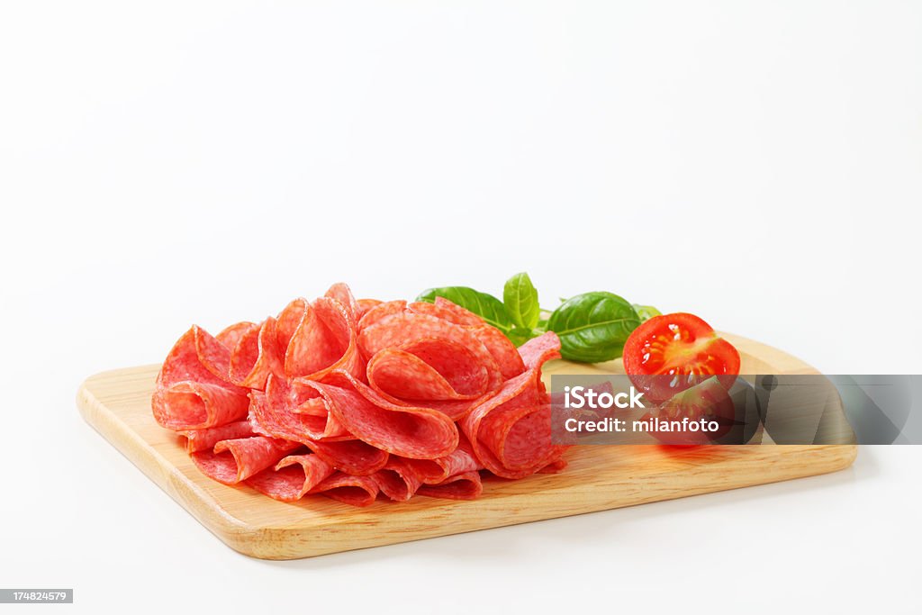 Salame italiano fatiado sobre uma tábua de corte - Foto de stock de Carne royalty-free