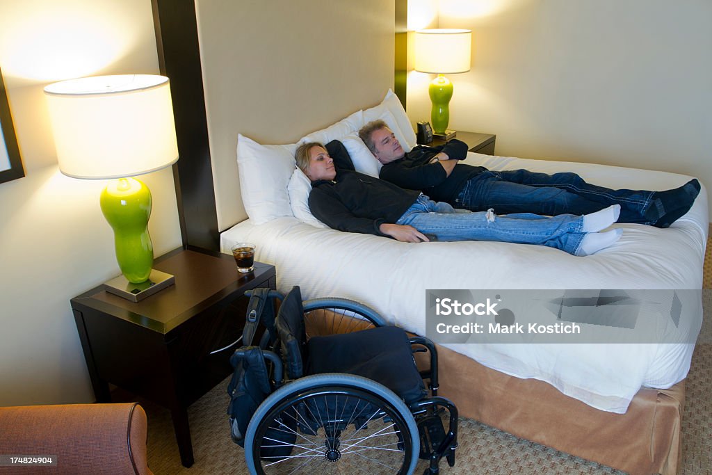 カップルのご不自由なお客様のためのホテルのベッドでリラックス - アクセスしやすいのロイヤリティフリーストックフォト