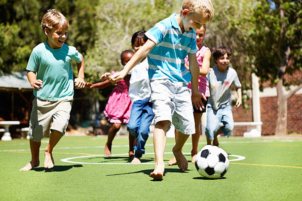 istock Young boy playing football with friends 174825009