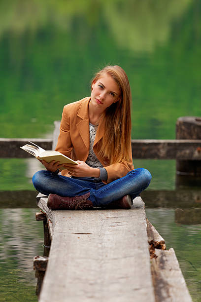 istock girl reading in the nature 174825281