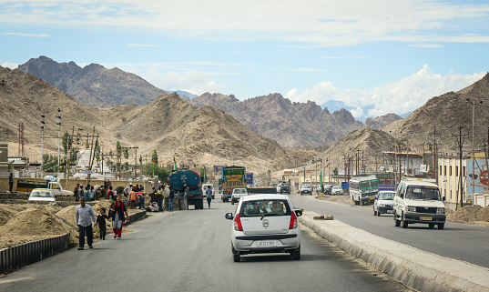Ladakh, India - Jul 20, 2015. Vehicles running on the mountain road under blue sky in Leh, Ladakh, India. Ladakh is one of the most sparsely populated regions in Jammu and Kashmir.
