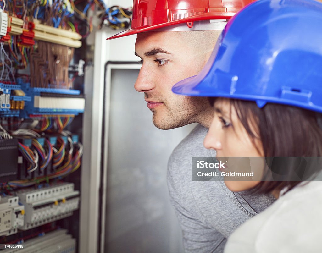 Patch Panel Inspection Young engineers inspecting the main patch panel in their factory. Factory Stock Photo