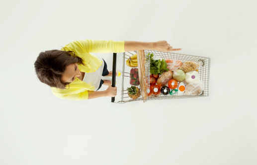 Young woman shopping groceries and pointinghttp://www.twodozendesign.info/i/1.png