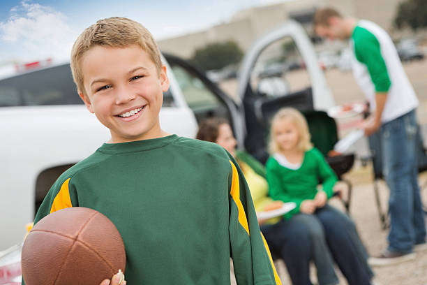 Cute little boy tailgating with family near college football stadium Cute little boy tailgating with family near college football stadium. people family tailgate party outdoors stock pictures, royalty-free photos & images