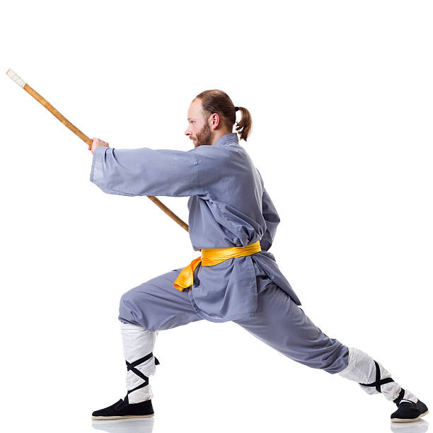 kung fu fighting position mit wushu cudgel, isoliert auf weiss - wushu action aggression power stock-fotos und bilder