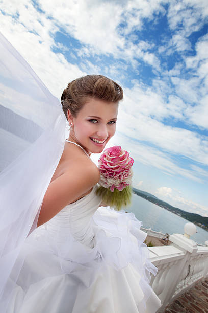 istock Beautiful Smiling Bride Sitting Outdoor and Looking  Over Shoulder. 174826496