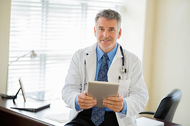 istock Confident Doctor With Digital Tablet Sitting On Desk 174826615