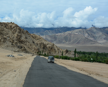 Ladakh, India - Jul 20, 2015. A car running on the mountain road at sunny day in Leh, Ladakh, India. Ladakh is one of the most sparsely populated regions in Jammu and Kashmir.