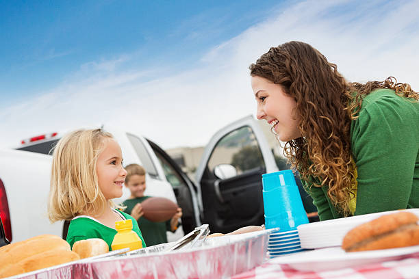 Little girl talking with fan at college football tailgate party Little girl talking with fan at college football tailgate party. people family tailgate party outdoors stock pictures, royalty-free photos & images