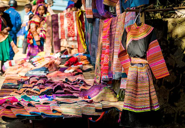 "colorful dress in Bac Ha market, VietnamColourfully dressed indigenous women of the Flower H'mong Ethnic Minority People at Bac Ha market in the backgroundshallow depth of field"