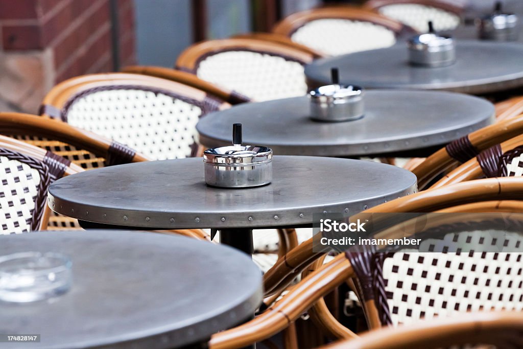 Restaurante al aire libre con fila de mesas, sillas y caña de ceniceros - Foto de stock de Aire libre libre de derechos