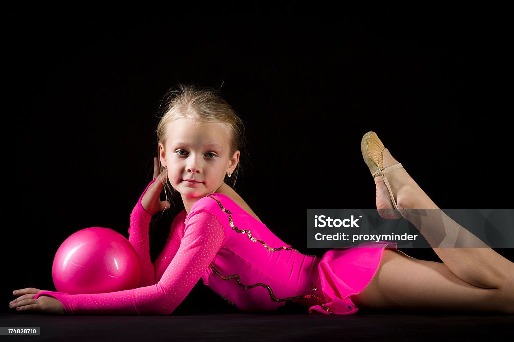 Little gimnasta Chica con ritmos de pelota sobre fondo negro - Foto de stock de 6-7 años libre de derechos