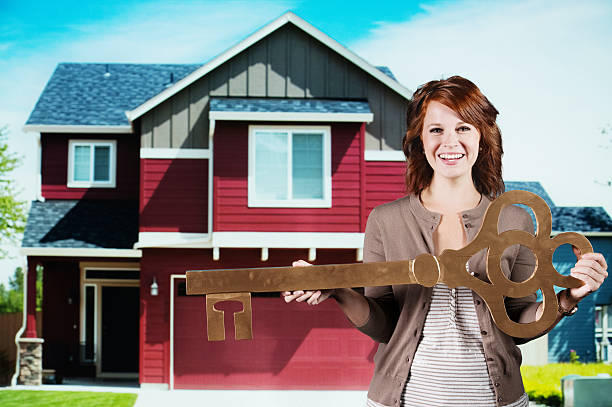 istock Happy young woman holding a large key 174828774
