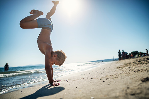 Little boy aged 8 is playing on the beach. The boy is doing a handstand. Summer sunny day in Tuscany, Italy.
Shot with Nikon D810