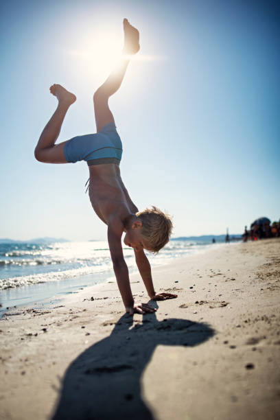 istock Little boy standing on hands on beach 1748289012