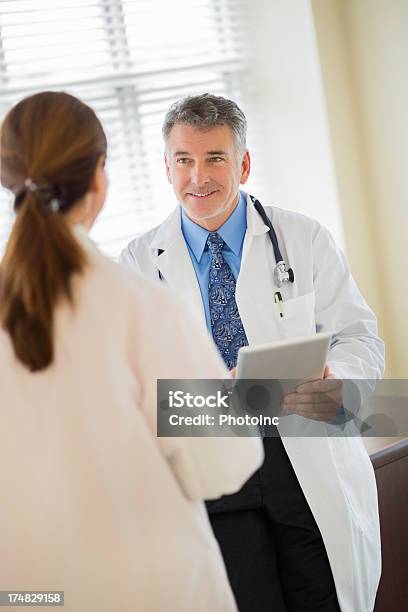 Médico Segurando A Discutir Com O Colega Comprimido - Fotografias de stock e mais imagens de Doutor