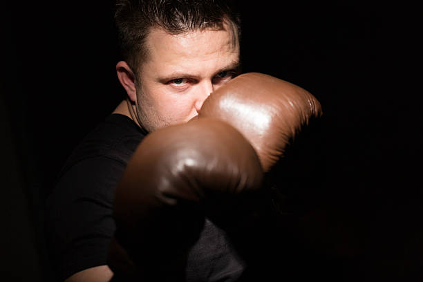 uomo con guantoni da boxe - conflict boxing glove classic sport foto e immagini stock