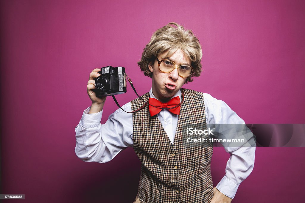 Nerdy Pink Background Photographer Student Young Man "Nerdy male photographer with a vest, huge glasses and a nerdy red bow tie holding a camera. Shot on a pink background with much copy space. This nerdy character is making a sad face." Men Stock Photo
