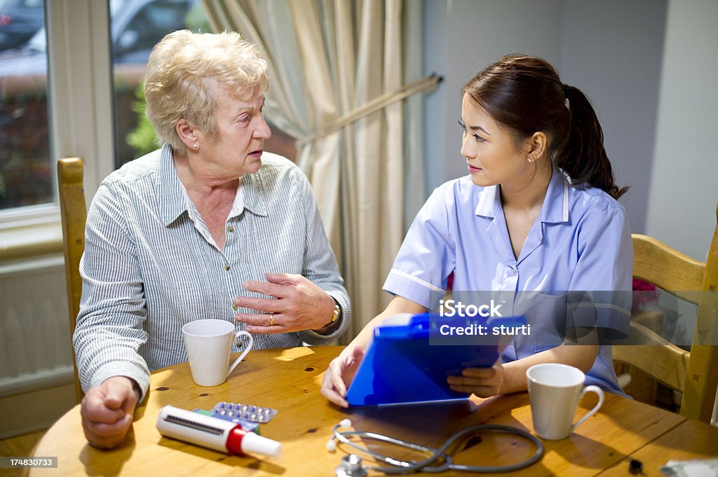 community infermiere effettuare una chiamata a casa per anziani - Foto stock royalty-free di 70-79 anni