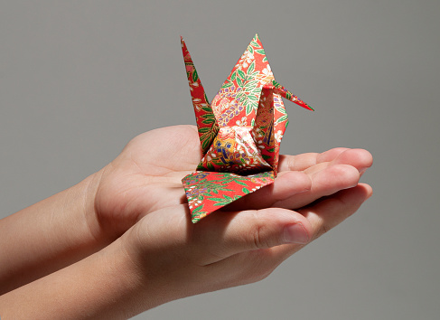 Hands of children carrying the origami.