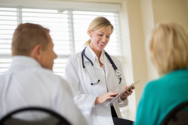 istock Doctor Using Digital Tablet With Couple In Foreground 174832528