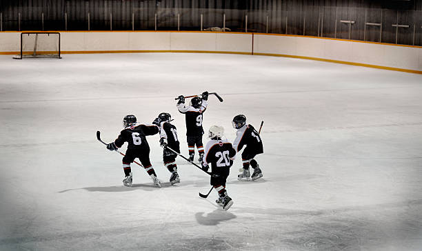 enfants équipe de hockey sur glace à la patinoire - ice hockey child childhood little boys photos et images de collection