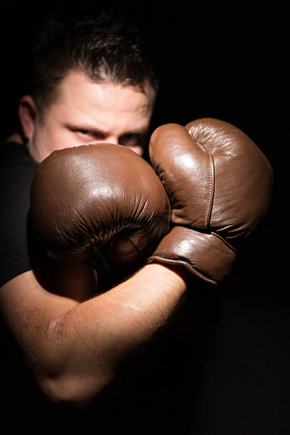 uomo con guantoni da boxe - conflict boxing glove classic sport foto e immagini stock